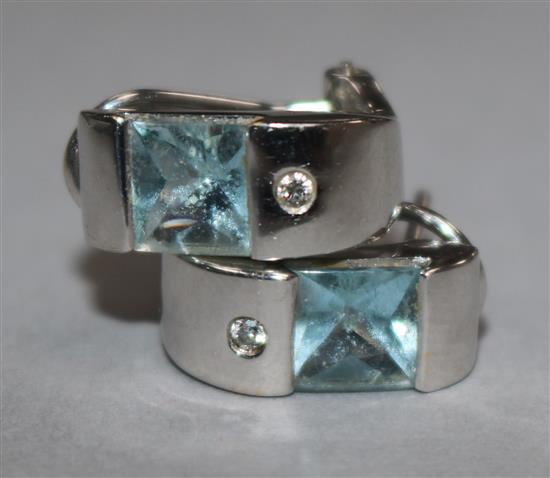 A pair of aquamarine earrings in white metal settings.